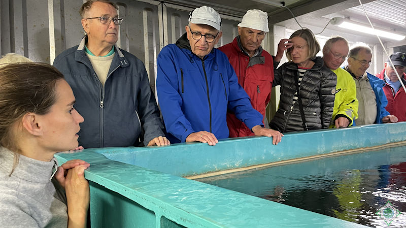 Das Bild zeigt die Pättkesgruppe aus Drensteinfurt neben dem 1. Vorsitzenden Franz-Josef Naber am Fischbecken in Vordergrund Louise Niehues, die Fischzüchterin. - Foto: © Gerty Münstermann
