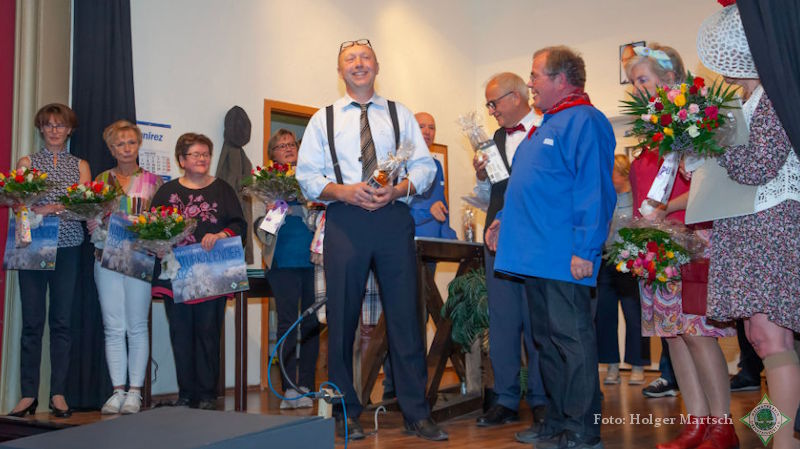 Blumen, den neuen Naturkalender des Heimatvereins und ein flüssiges Dankeschön überreichte Vereinsvorsitzender Franz-Josef Naber (in Kiepenkerl-Tracht) den Beteiligten bei der Abschlussvorstellung. Foto: Holger Martsch